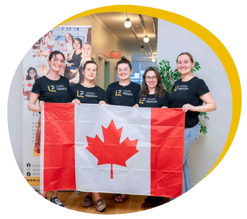 The Learn French team holding the Canadian flag